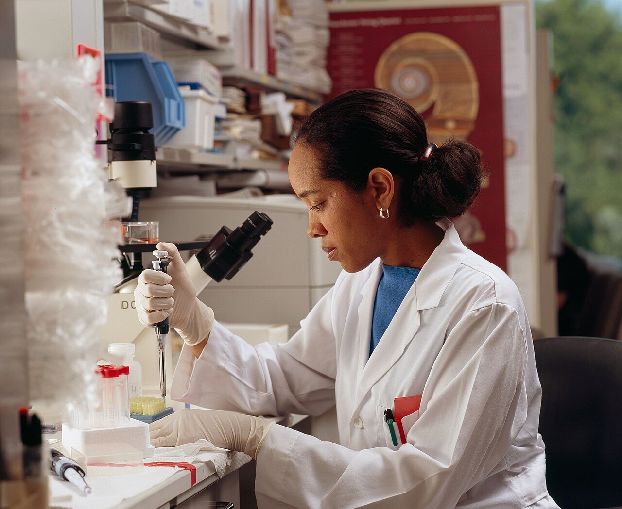 A National Cancer Institute researcher uses pipettes at a laboratory bench.